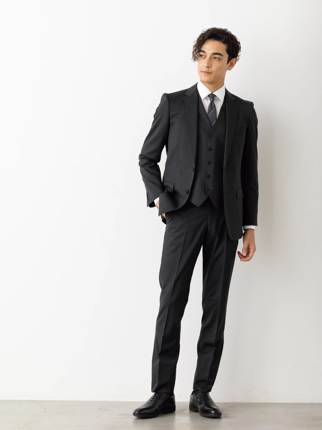 黒のスリーピーススーツを着た男性