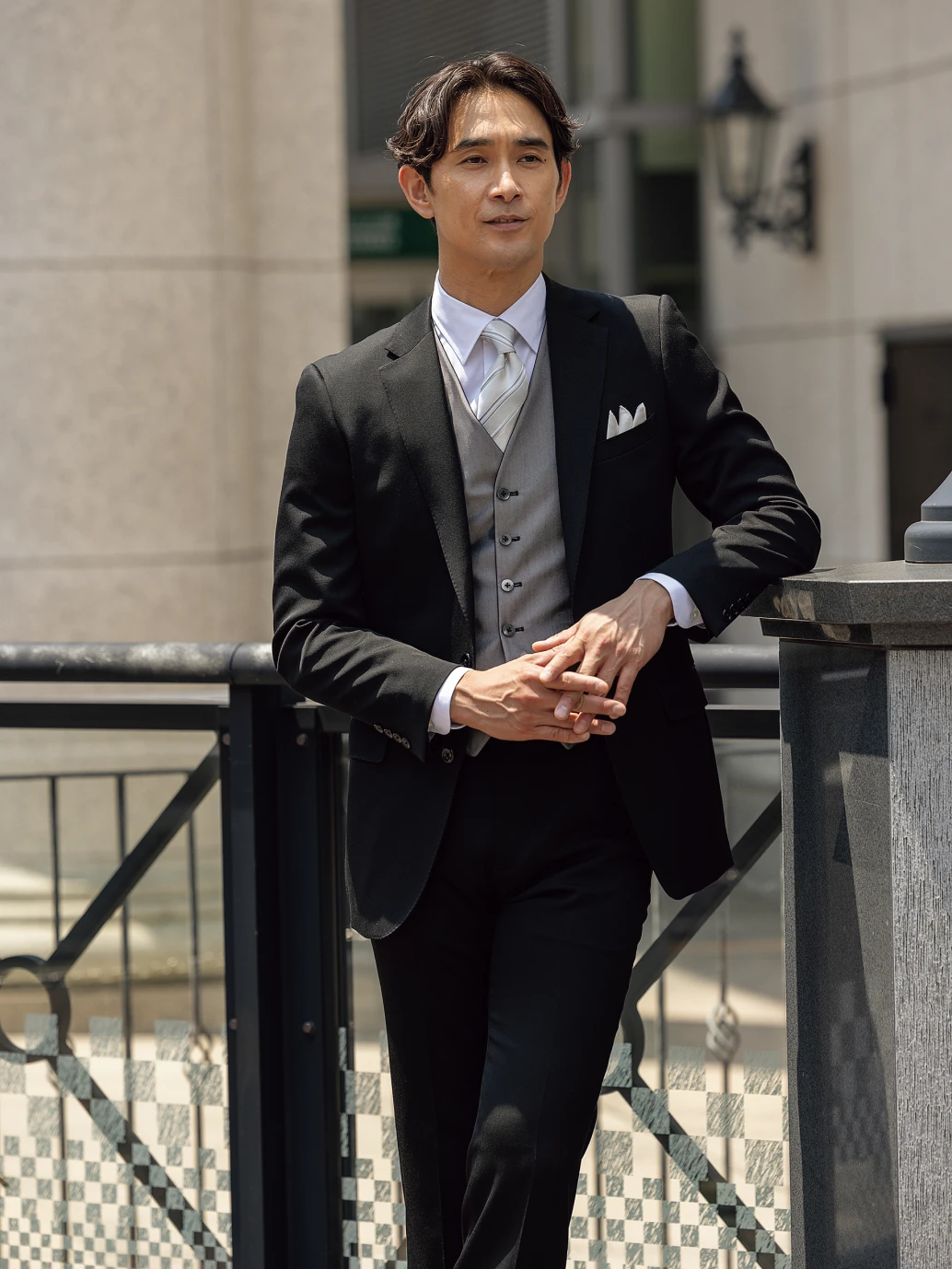 黒のスーツにグレーのベストを合わせた男性