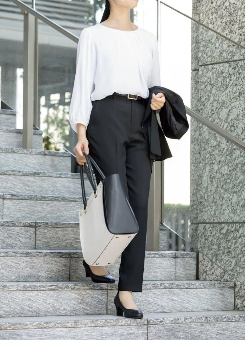 白のタックブラウスと黒のパンツで清潔感を演出
