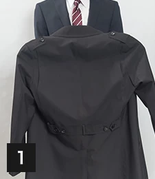 コートの両肩に裏から手を入れます。